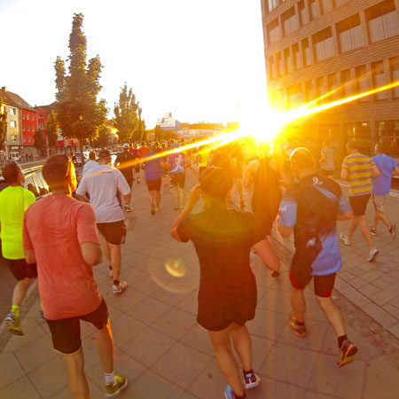 Laufgruppe vor einem Sonnenuntergang